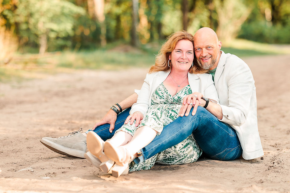 man en vrouw zitten in het zand