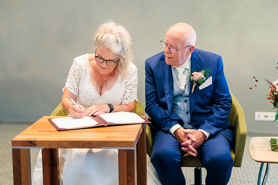 vrouw tekent de huwelijksacte