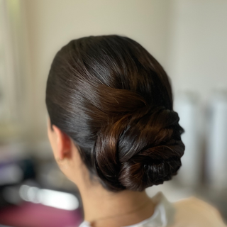 Chinese bride with a sleek, low smooth and shiny bun for a traditional yet modern look.