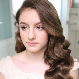 Bride with soft, brushed-out Hollywood waves cascading over her shoulder, styled with a side part for a timeless elegant look.