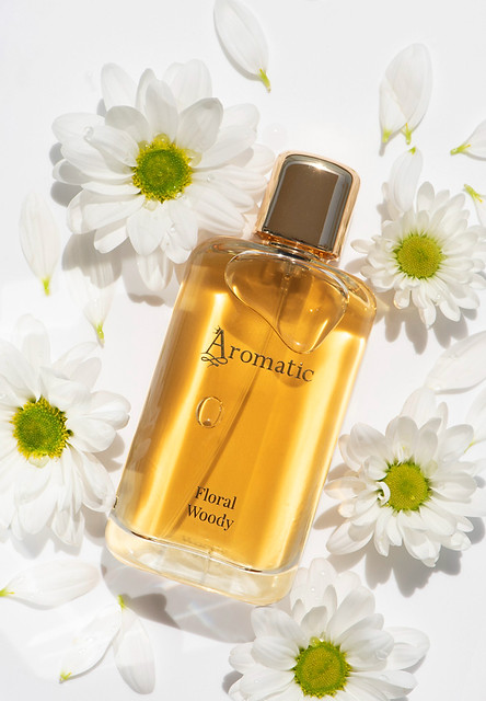 a life stye photo of a perfume on the fowers around it