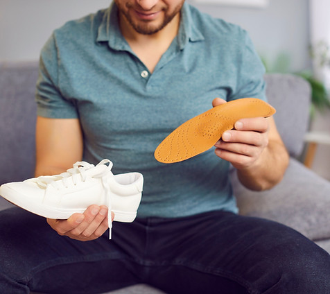 man-inserting-orthopedic-insole-shoe.jpeg