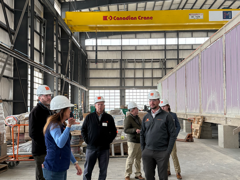 Group of 6 open house attendees standing in factory next to ER expasion project for Beth Israel Milton