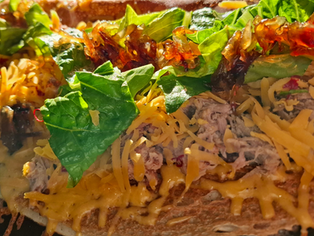 trhané maso v pohankové palačince s karamelizovanou cibulkou, cheddarem a salátem