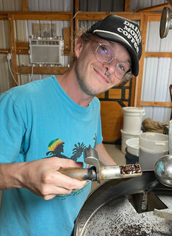 Primary Roaster Zach pulling coffee samples from roasting machine