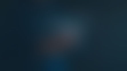 Person in a dark shirt uses a smartphone with a digital financial graph overlay. Dark background with glowing blue and orange lines.