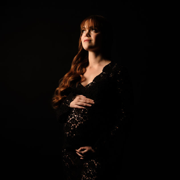 Portrait studio d'une femme enceinte avec une robe noir en dentelle 