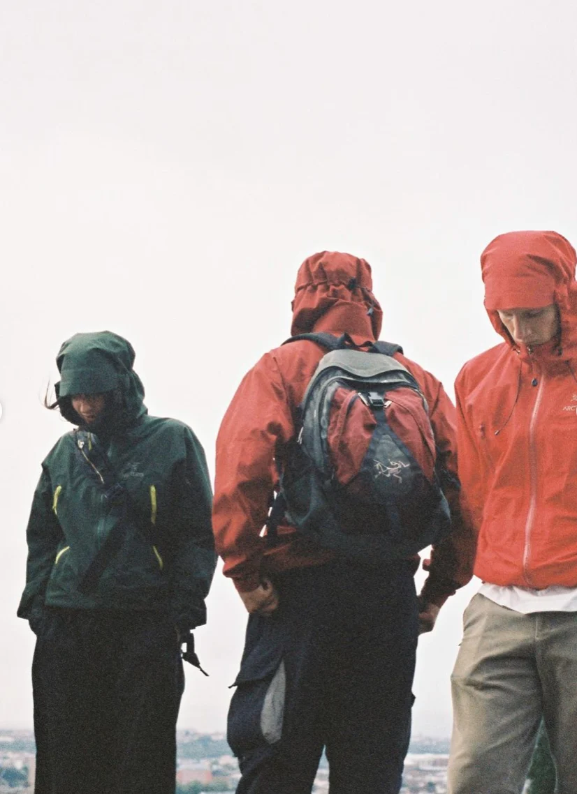 Three people in hooded jackets, one with a backpack