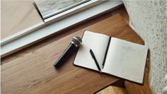 Microphone next to a notebook on a desk