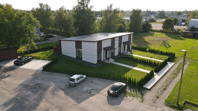 Moodne ja esteetiline välimus: Uusarendus paarismaja hallikasvalges krohvi ja pruuni puitlaudiga kombineeritud fassaadiga pakub kaasaegset ja stiilset välimust, mis sobib ideaalselt linna- või äärelinnakeskkonda. See värvikombinatsioon on elegantne ja rafineeritud, pakkudes samas hubast ja kutsuvat atmosfääri.