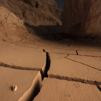 Cracked desert earth inside a dry cave showing unique geological textures in Israel.