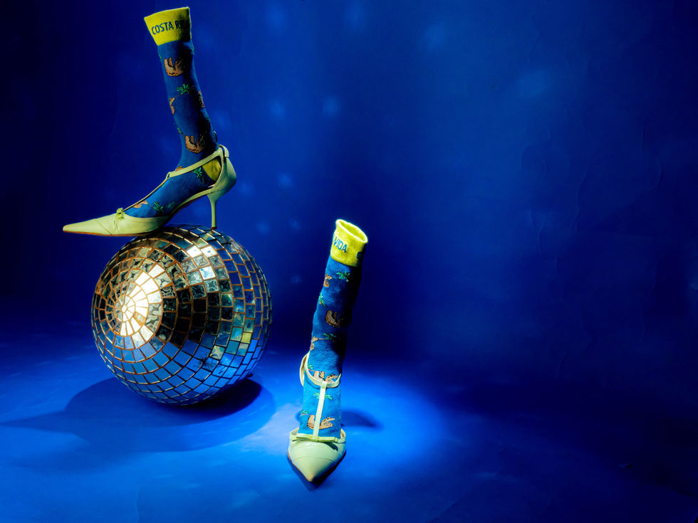 Product shoot of sock shoes on a blue background, set in a playful and quirky universe. Aiming to make the packshot fun and lively, with strong contrasts.

Keywords: product photography Paris, sock shoes, packshot photography, playful product shoot, blue background, vibrant contrasts, fashion product photography.