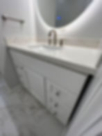 White bathroom vanity with snow white quartz counter top and LED backed mirror installed MLP Paint And Tile for a bathroom remodel in Scarsdale NY.