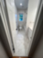 1960s bathroom transformed into a modern-day upgrade with wood-look porcelain tile in a bathroom remodel in Purchase NY.