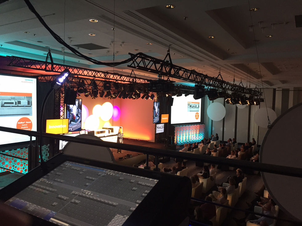 Conference with audience and colorful stage lighting.