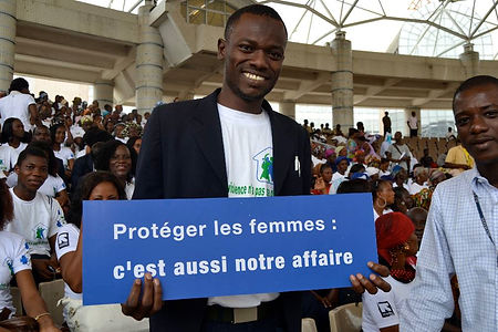 Man holding sign at Break the Silence launch, IRC, Côte d'Ivoire