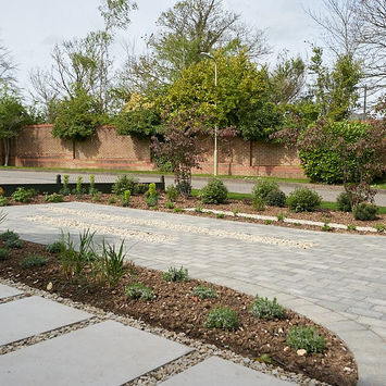 A front garden and driveway thoughtfully combined with stunning design elements to create a space that is both functional and beautiful.