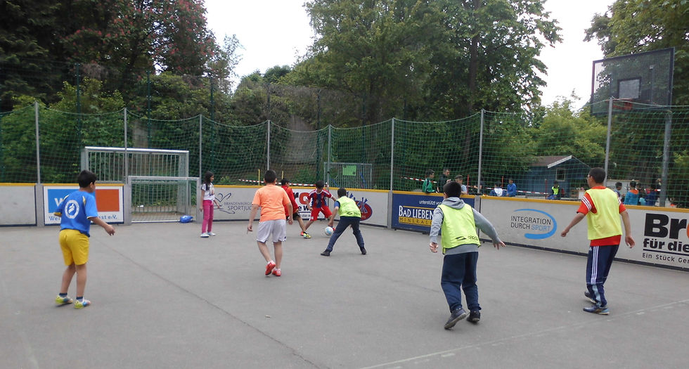 Schülerinnen und Schüler spielen Fußball auf dem Schulhof