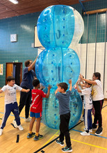 Kinder in der Sporthalle mit Riesenbällen