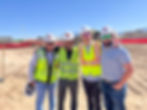 4 men in hard hats at construction site
