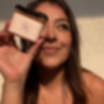 Mujer bronceada sonriendo mientras sostiene una brocha aplicadora para autobronceado AU79 Tan.