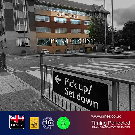 Pick-up and drop-off point at Farnborough Main Station showing Spectrum Point building and pedestrian crossing in Hampshire.  Image showing the official taxi pick-up and drop-off point at Farnborough Main Railway Station in Hampshire, located opposite Spectrum Point building. Includes pedestrian crossing, roadside signage, and Dinez Train Station Taxi branding.