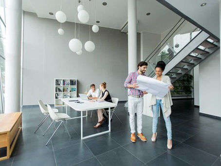 modern office interior design with open layout, minimalist furniture, and natural lighting, featuring architects reviewing plans