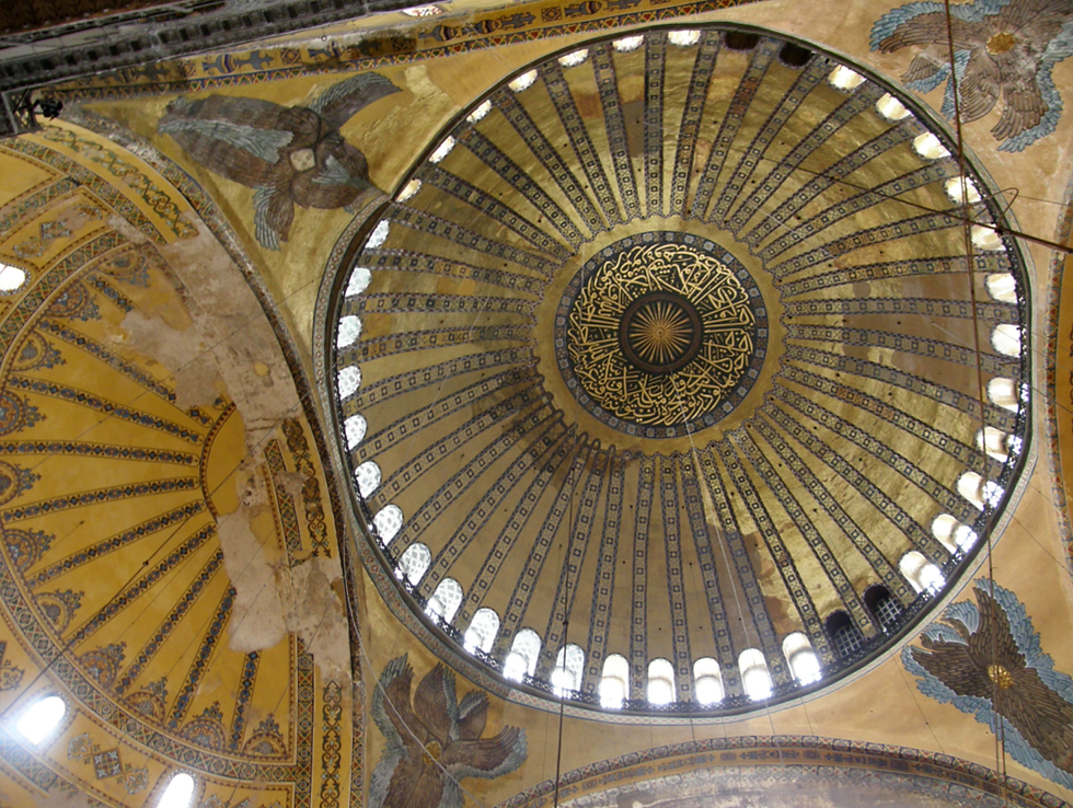 Interior dome of Hagia Sophia in Istanbul featuring golden Byzantine mosaics, Islamic calligraphy medallion and angelic seraphim frescoes illuminated by natural light