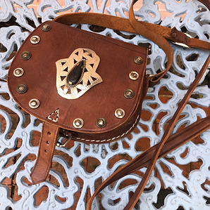 Hand tooled Moroccan leather saddle bag with metal hamsa hand