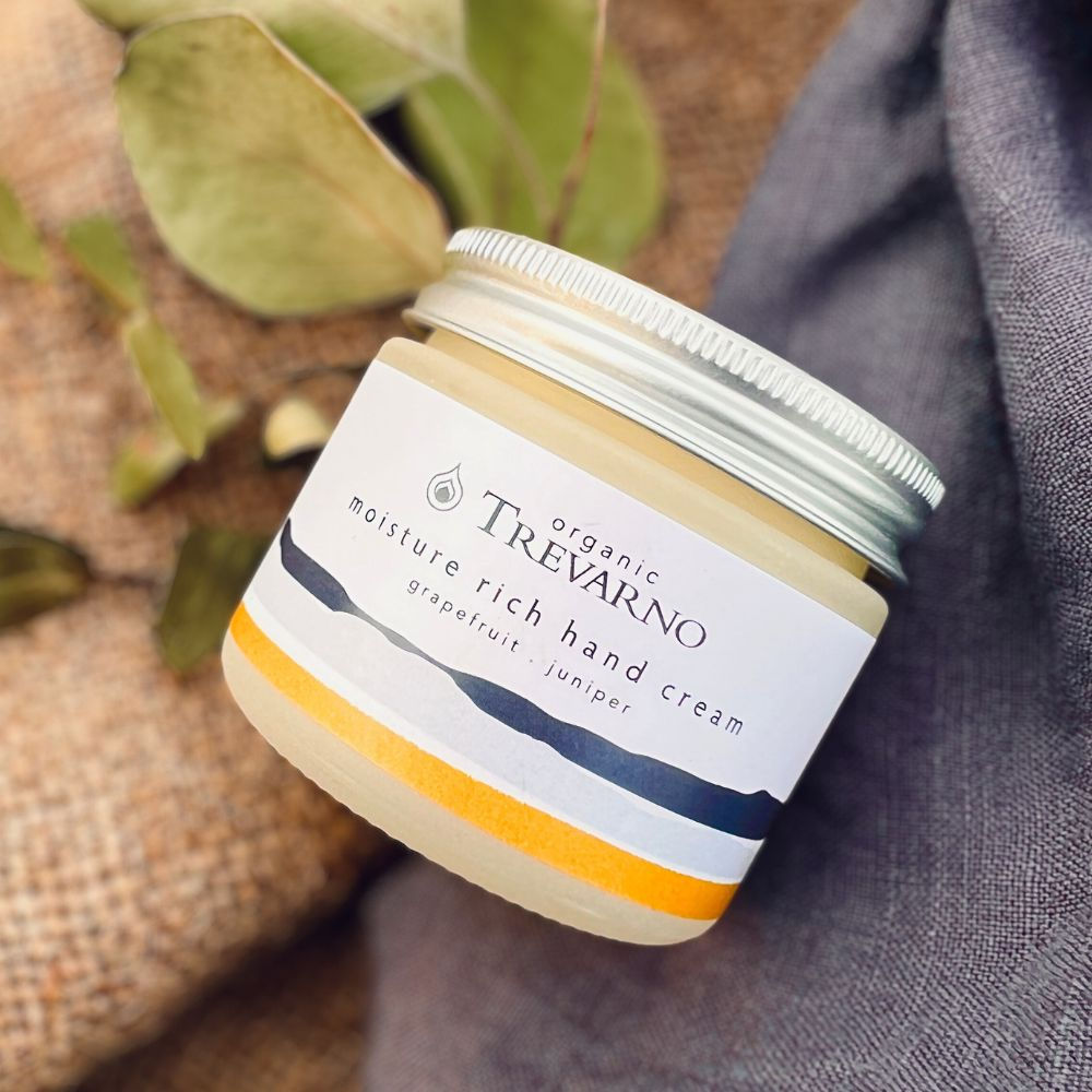 Organic Trevarno Moisture Rich Hand Cream tube on natural fabric, highlighting organic ingredients, sustainable