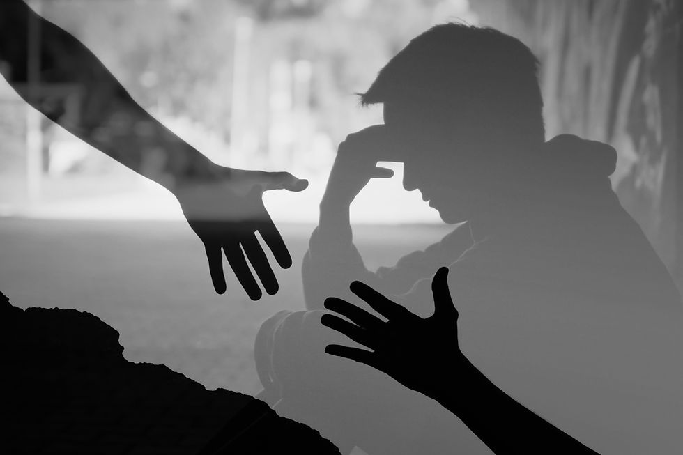 Two hands reaching out to help each other in front of man struggling with mental health.