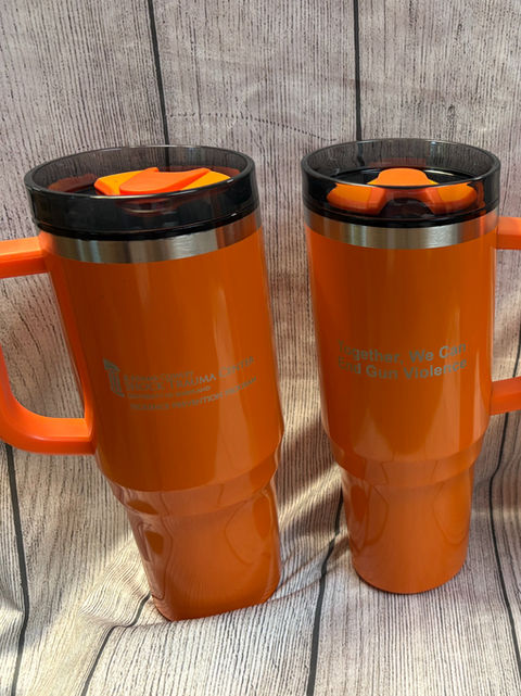 Two bright orange thermal tumblers with black lids, featuring a unique custom print . Popular event and corporate giveaway items.