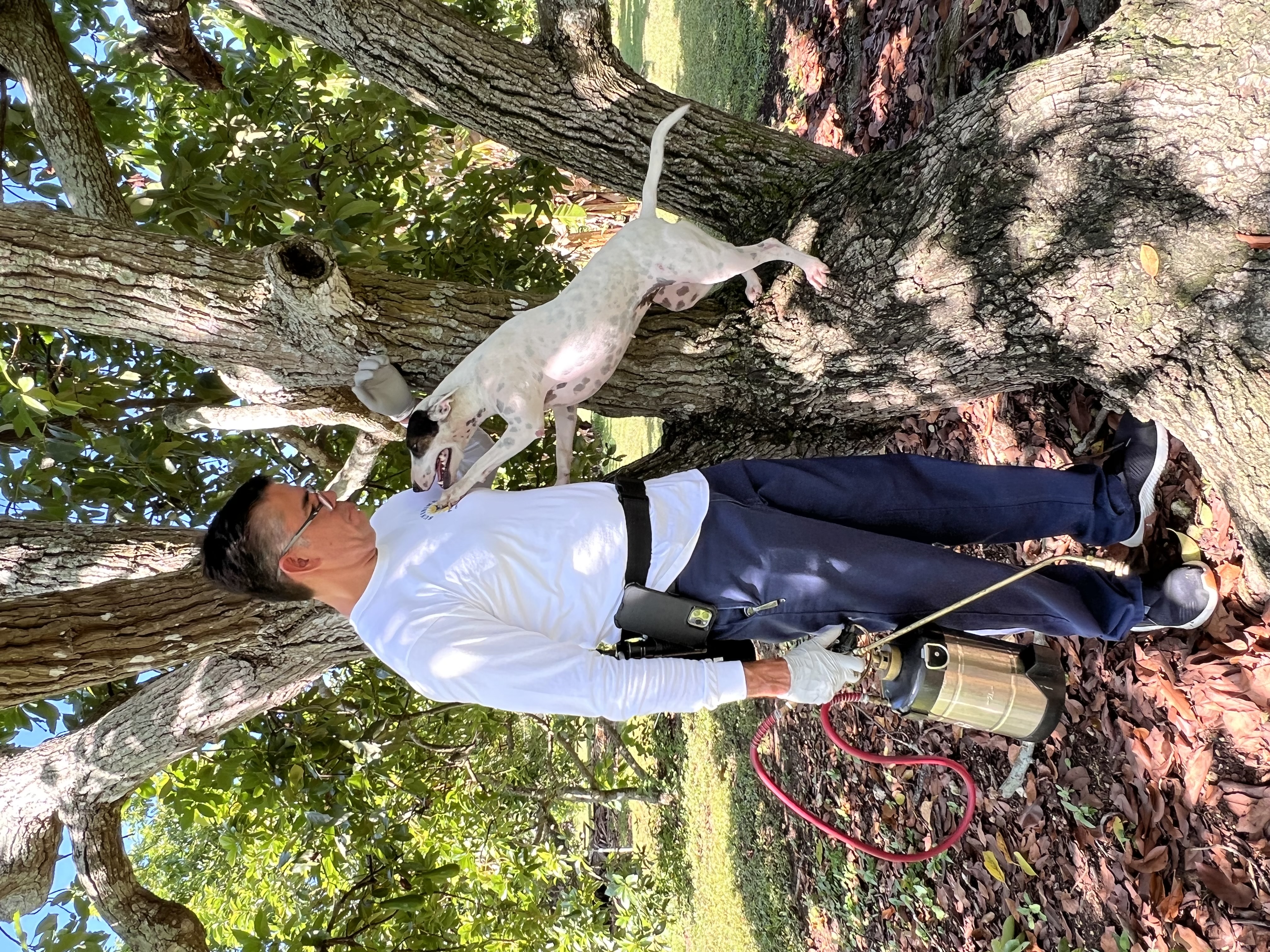 Sunshine Pest Control technician with a friendly dog in a Miami yard