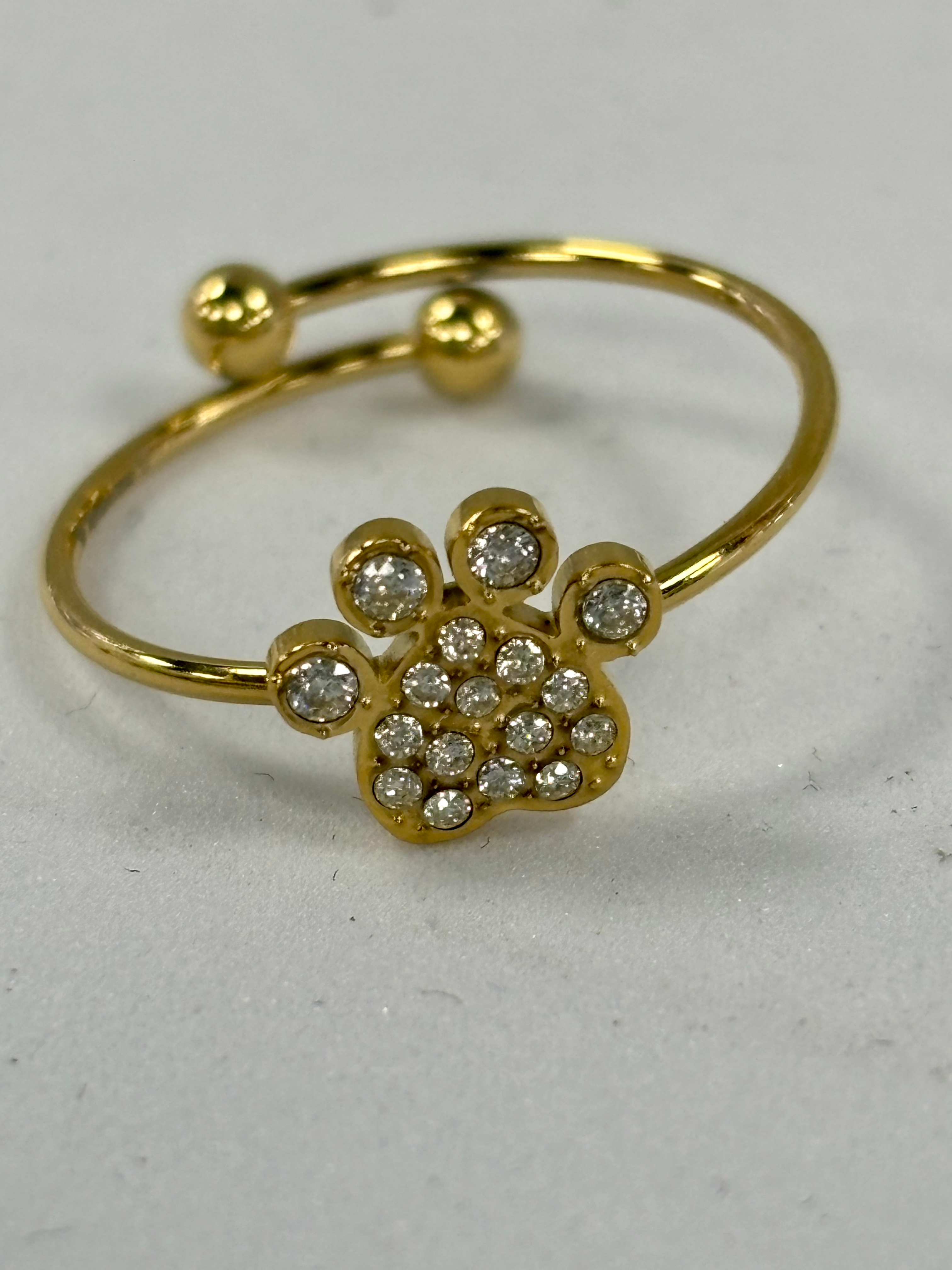 Anello in acciaio dorato regolabile con zampa