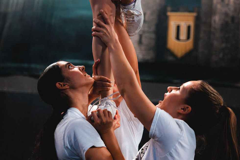 Backspot and bases stabilizing a cheerleading stunt during a Barcelona Bears training session.