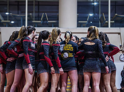 Equipo de cheerleading en un circulo haciendo un grito juntos