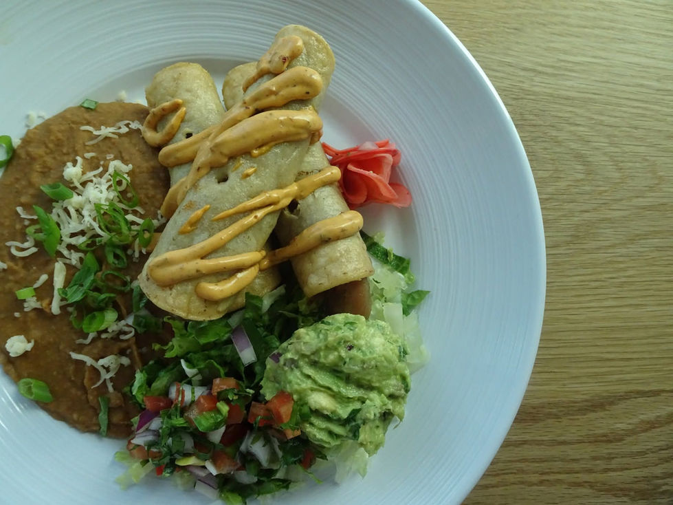 a white plate topped with tacos guacamole and beans