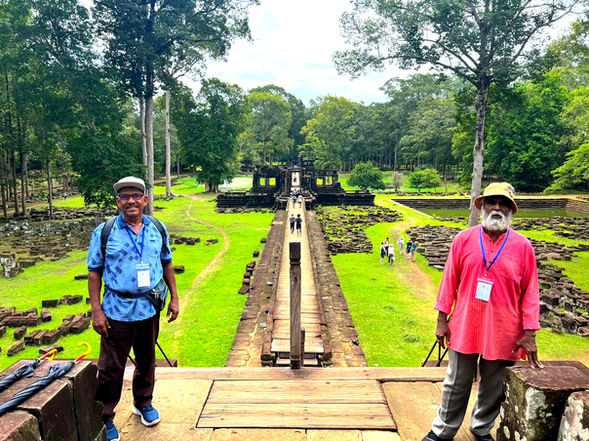 Visitors standing on the stone causeway leading to Baphuon Temple inside Angkor Thom, Siem Reap, Cambodia.