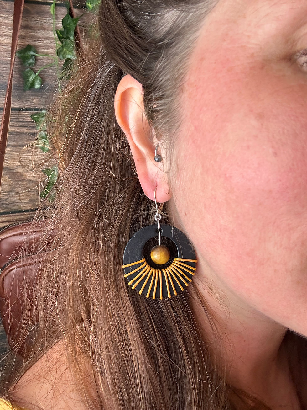 Miniature : Zoom porté des boucles d’oreilles Sundara noires avec cuir travaillé à la main et pierre Œil de Tigre