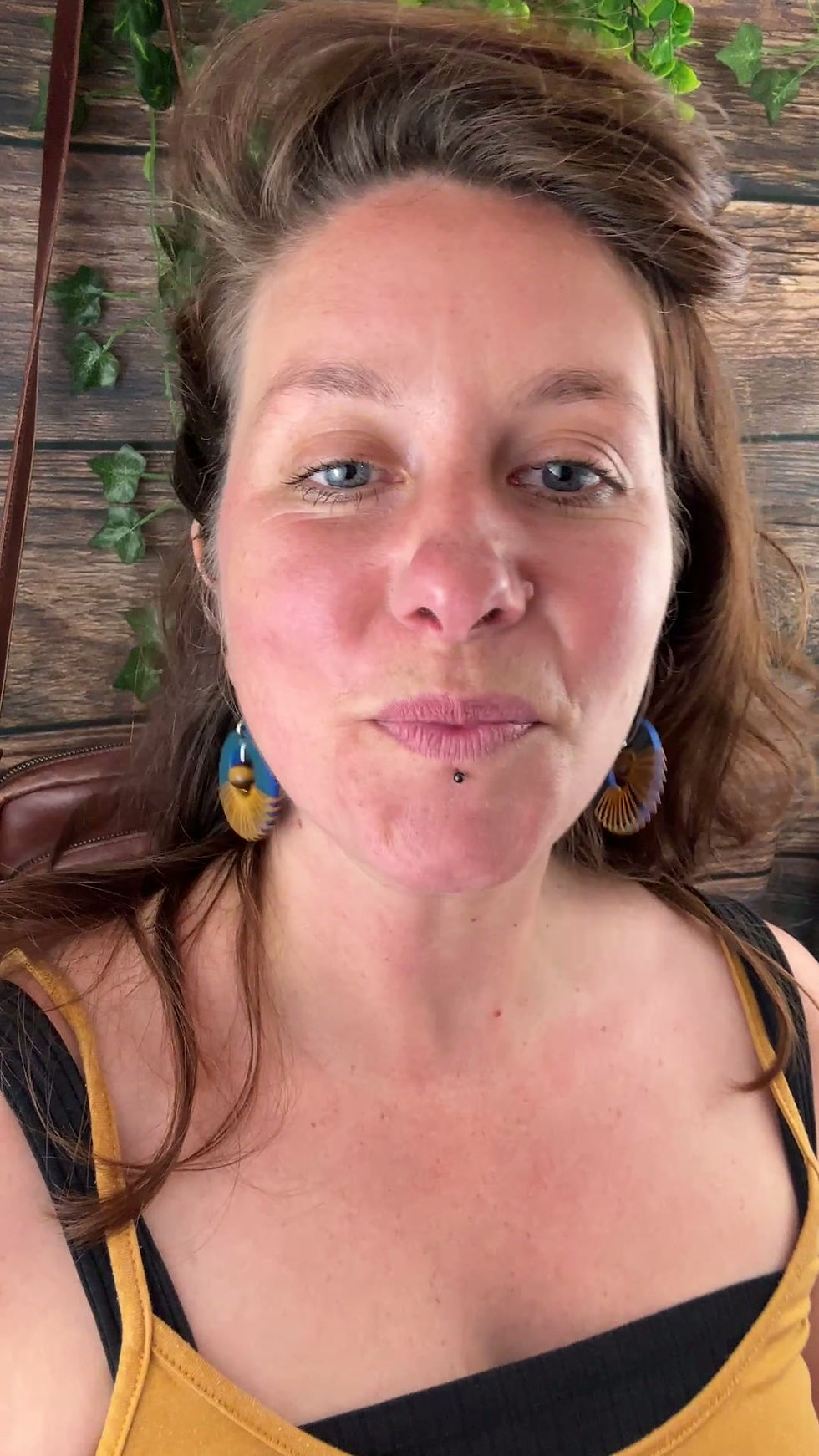 Miniature : Vidéo d’une femme portant les boucles d’oreilles artisanales Sundara en cuir bleu et pierre Œil de Tigre en mouvement