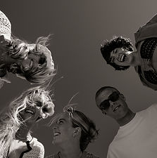 Group of young adults in a group looking down at camera in B&W