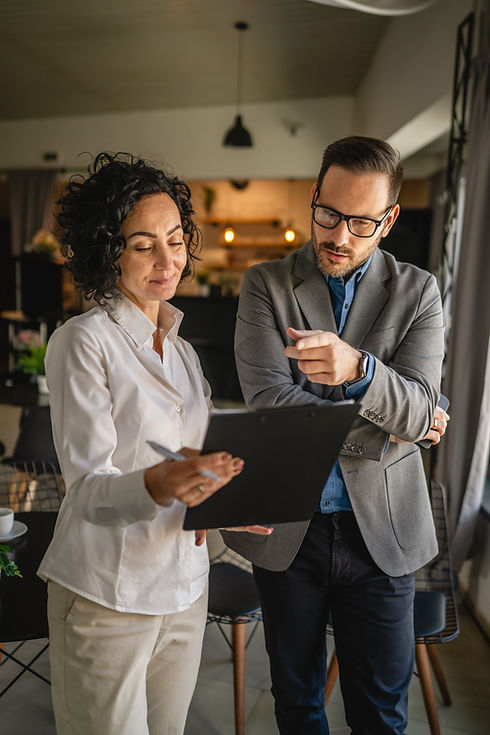 Colleagues stand in cafe woman hold document and man hold mobile phone.jpg