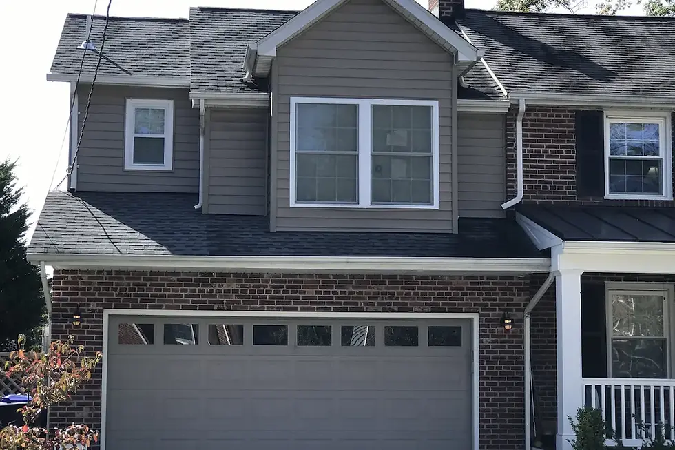 Two-story rear sunroom addition with new gabled roof tied into the existing roofline of an Alexandria-area home