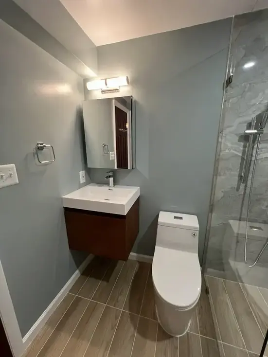 walk-in shower remodel Alexandria VA — floor-to-ceiling marble-look porcelain tile by Vale Construction