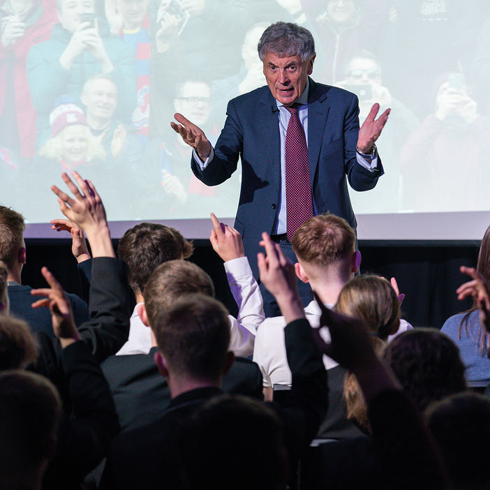 Man giving presentation; audience asks questions