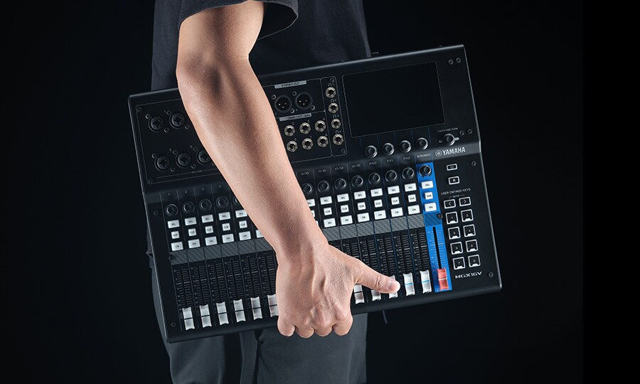 Vue rapprochée d'une table de mixage Yamaha avec des boutons et faders