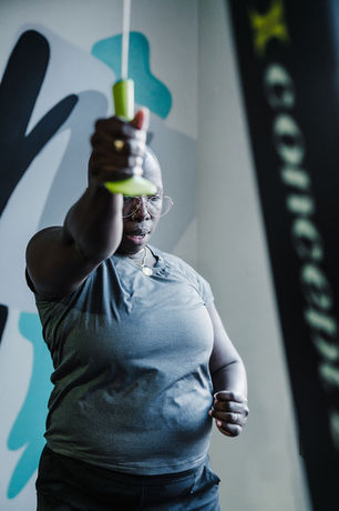 Woman practicing with a training device in a gym near graffiti wall
