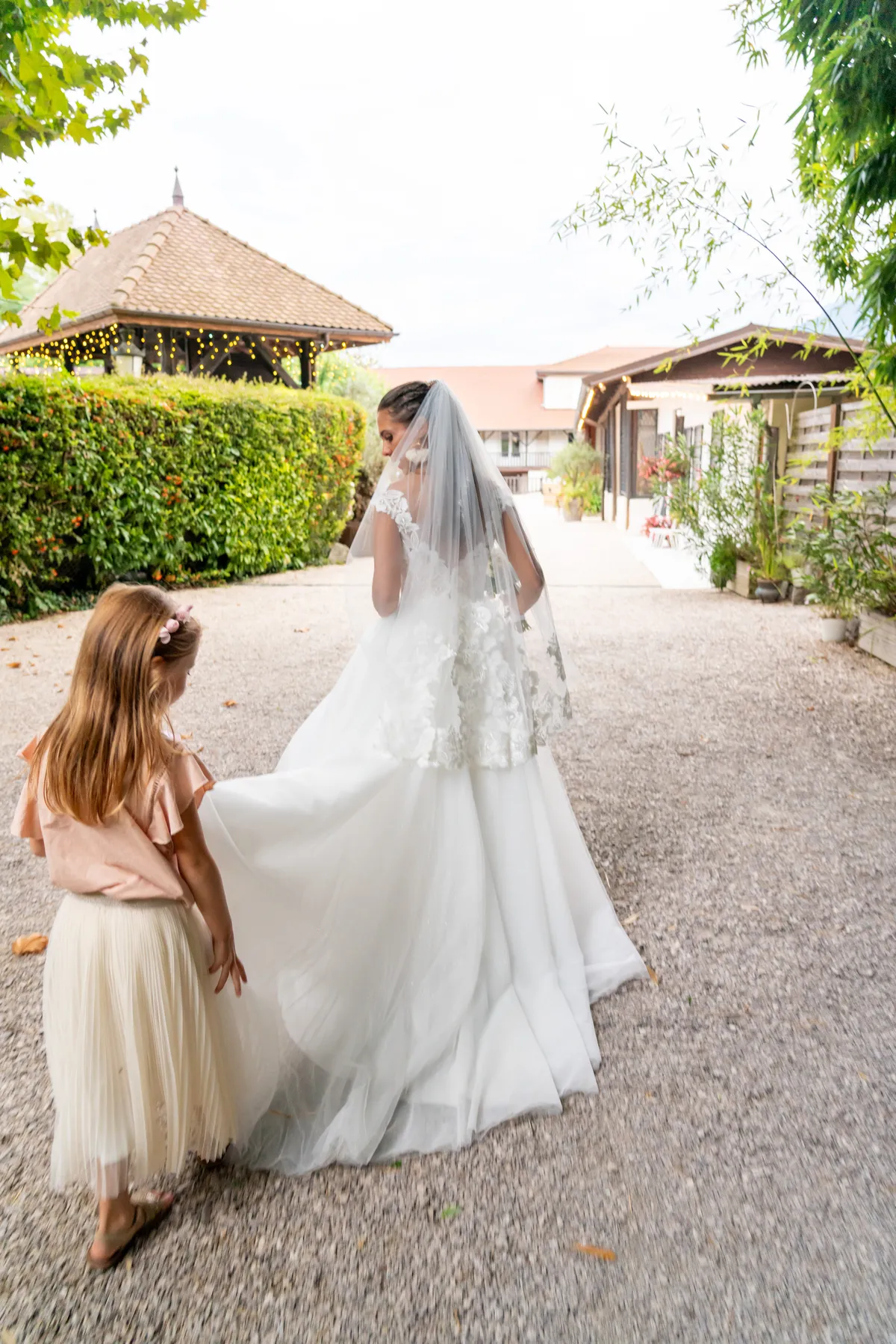 Une petite fille tient la traîne de la mariée au Clos de Florie en Savoie