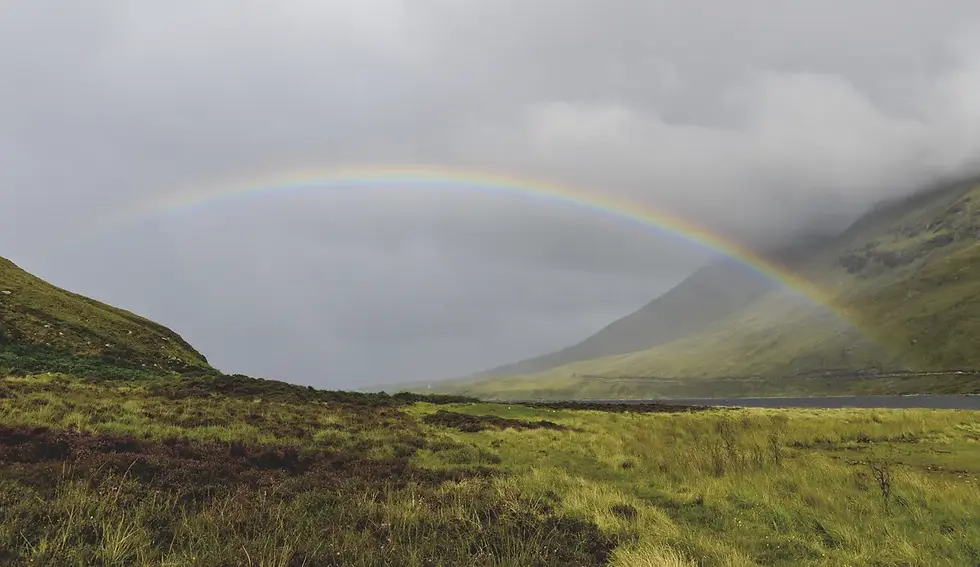 Photographe - arc-en-ciel vibrant au-dessus de collines verdoyantes sous un ciel nuageux, paysage paisible et naturel en Ecosse. 