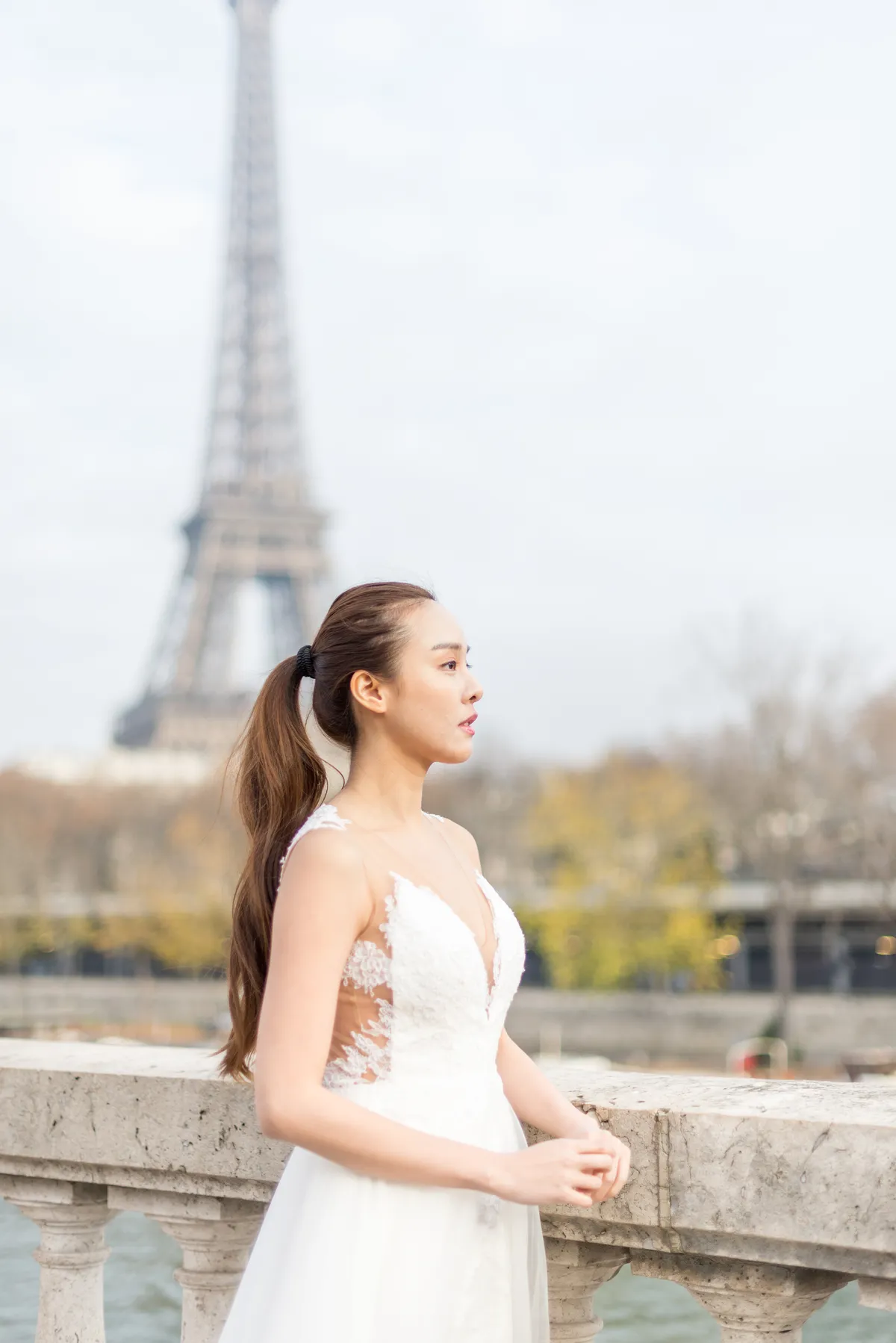 Photographe mariage – jeune femme en robe de mariée face à la Tour Eiffel